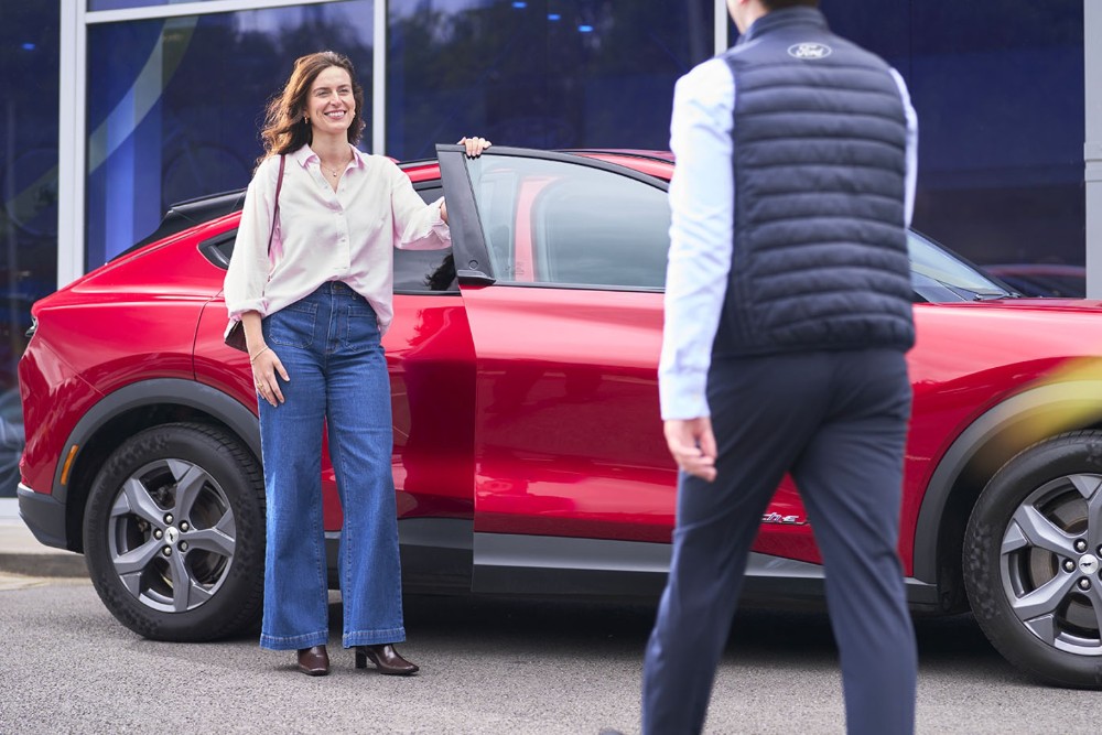 Cliente davanti una Mustang Mach-E rossa.