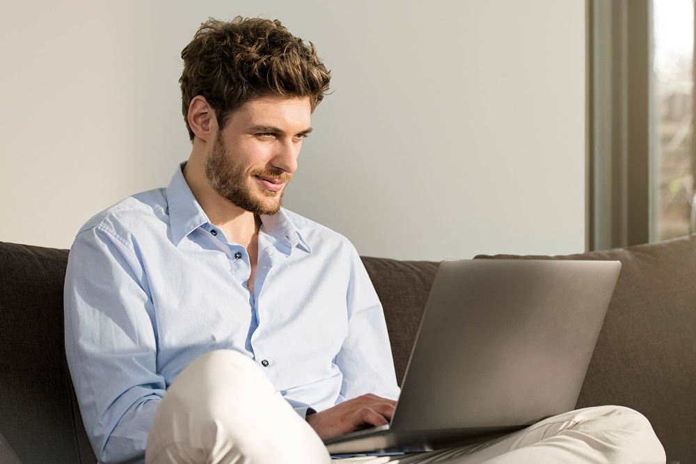 Modules man sitting on couch with laptop