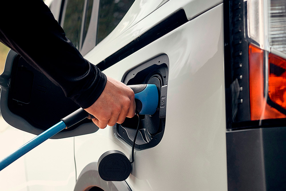 Una persona che collega un veicolo elettrico Ford a un cavo di ricarica EV.