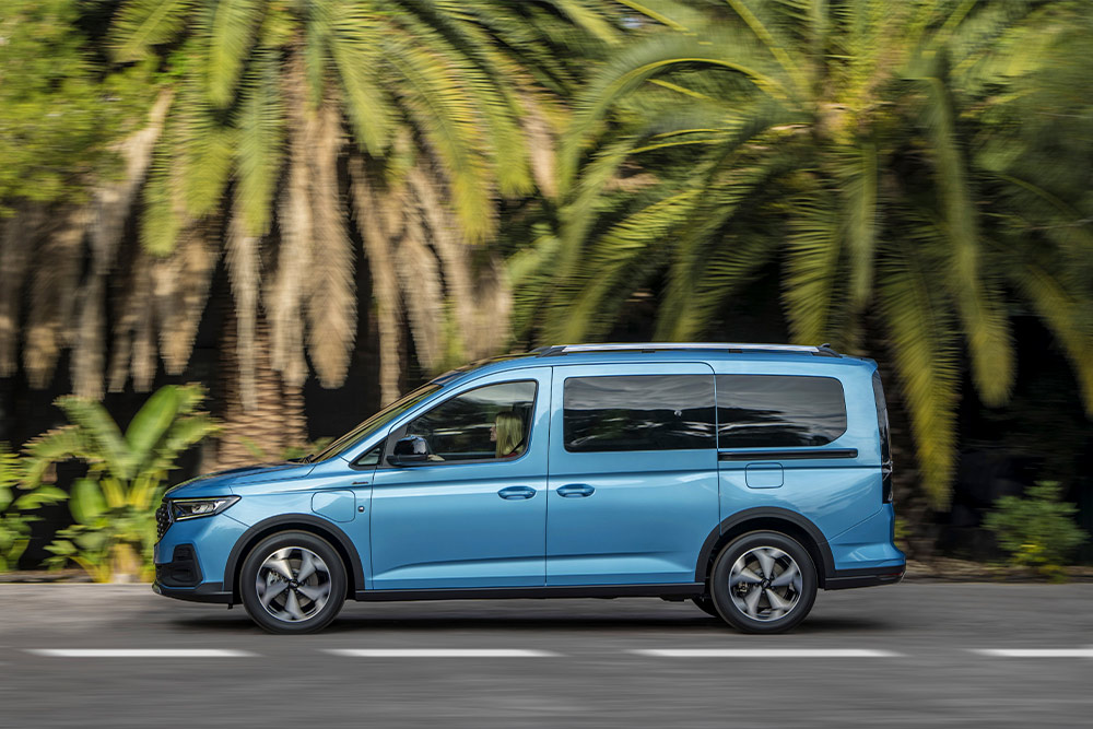 Un furgone Plug-In Hybrid Ford Tourneo Connect blu parcheggiato su una strada.