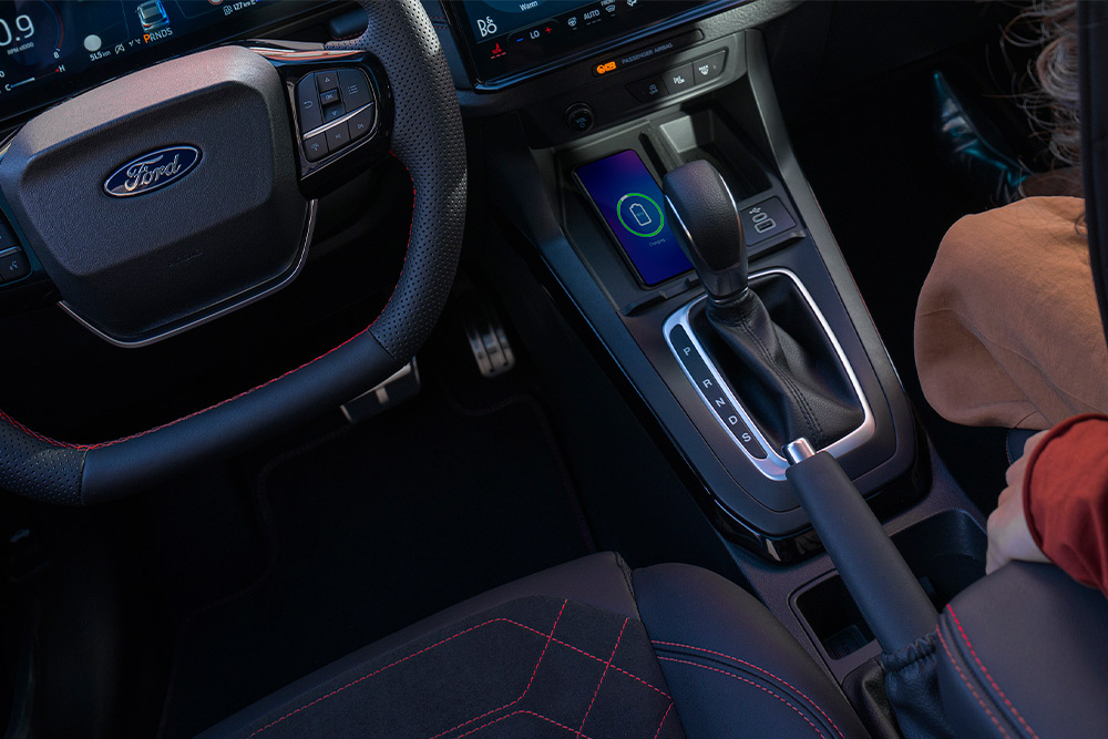 Vista interna di un'auto mild hybrid Ford, compresi il volante e la leva del cambio automatico.