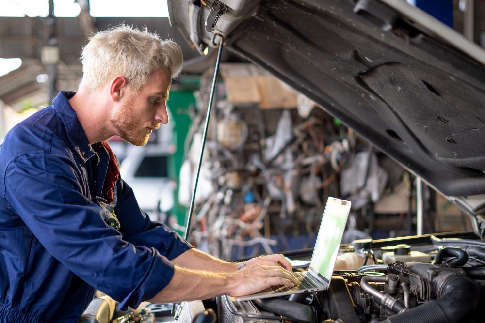 Un addetto alla manutenzione controlla l'auto utilizzando un computer
