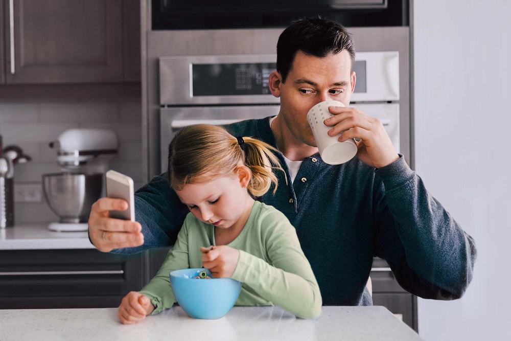 Uomo con una bambina che controlla il cellulare