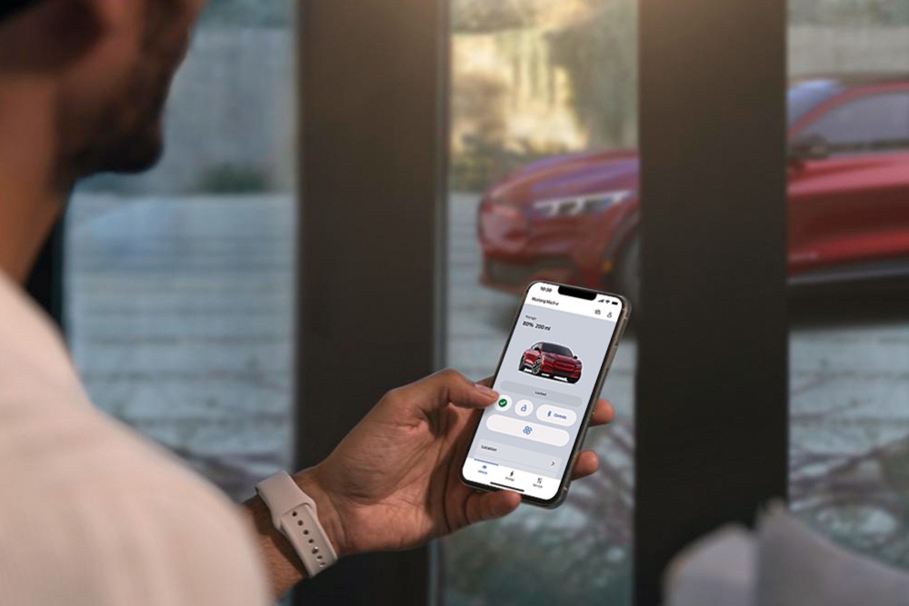A man checking the settings of his All-New Ford Mustang Mach-E using the Remote Vehicle Control features in the FordPass app