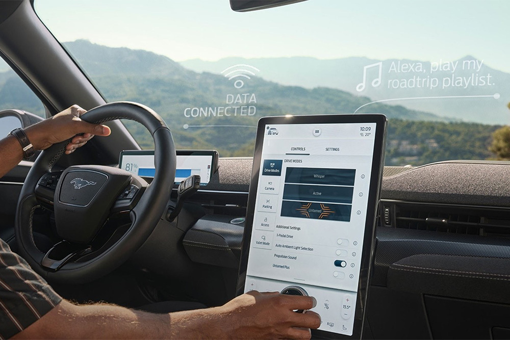 Primo piano del conducente di un Ford Mustang Mach-E che interagisce con il grande touchscreen SYNC 4 da 15,5"