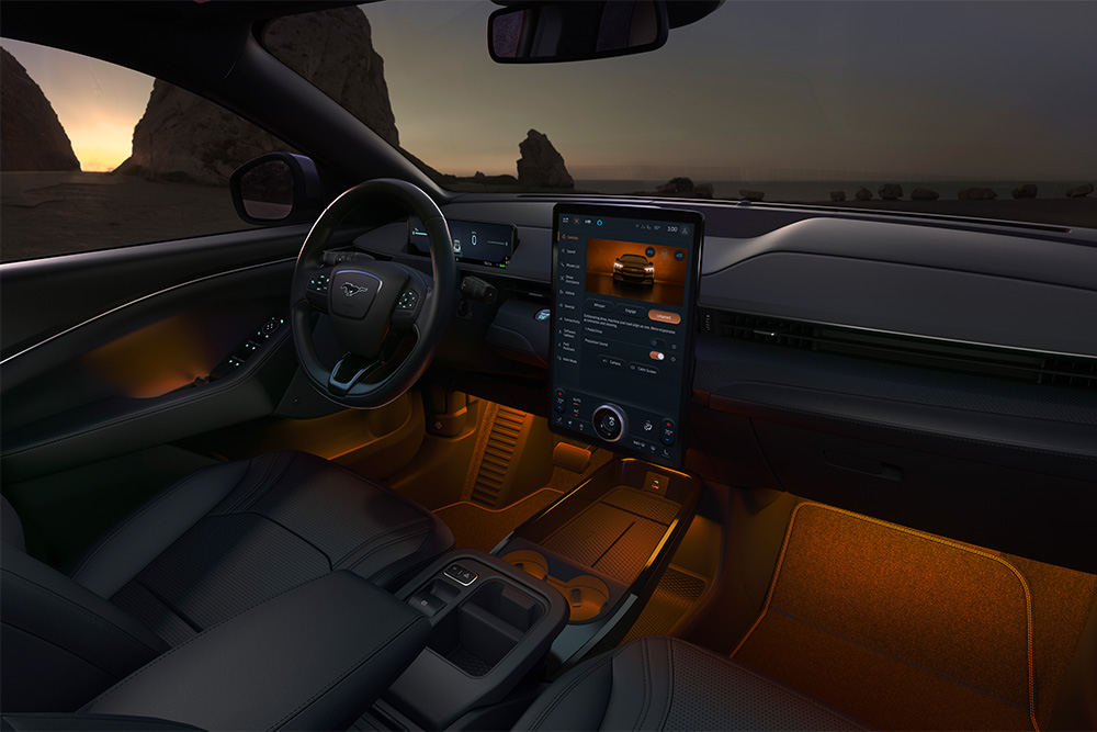 Interni del Ford Mustang Mach-E: il touchscreen SYNC 4  da 15,5"" e l'illuminazione a LED ambientale impostata sull'arancione