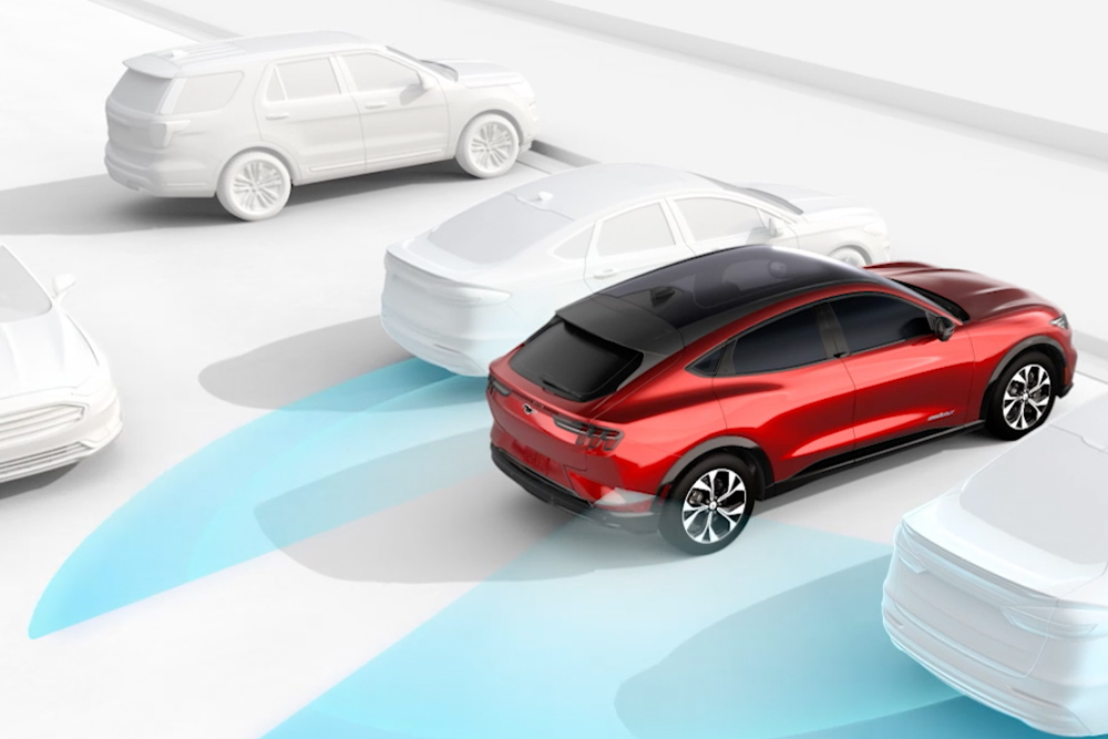 Una Ford Mustang Mach-E rossa con sensori blu illustra il Blind Spot Information System e il Cross Traffic Alert