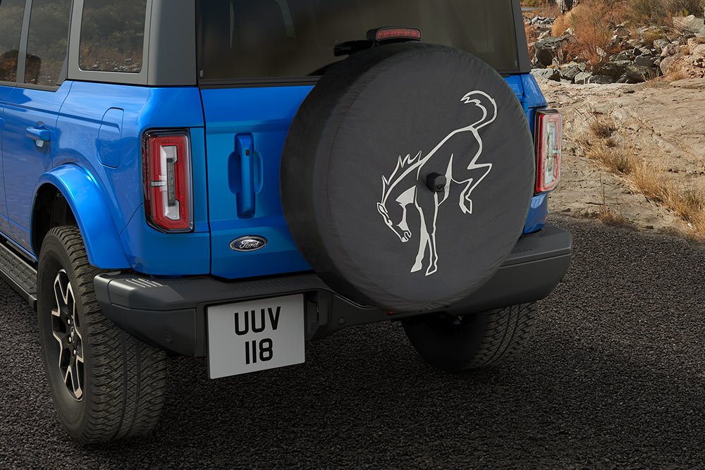 Vista posteriore di un Ford Bronco blu con una ruota di scorta montata sul retro.