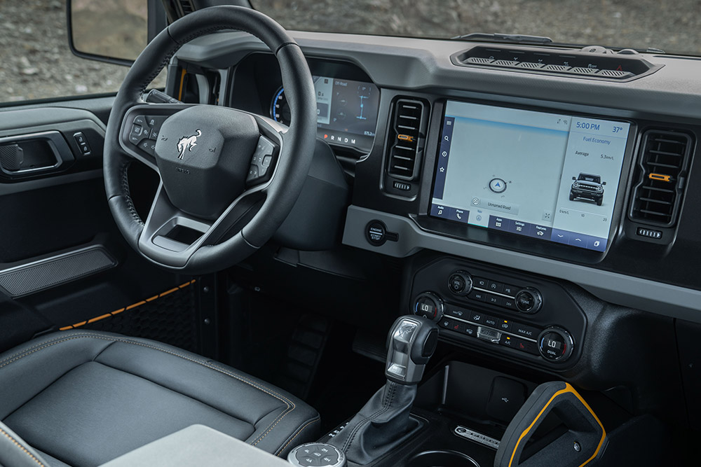Vista degli interni del Ford Bronco, con volante in pelle e touchscreen connesso.