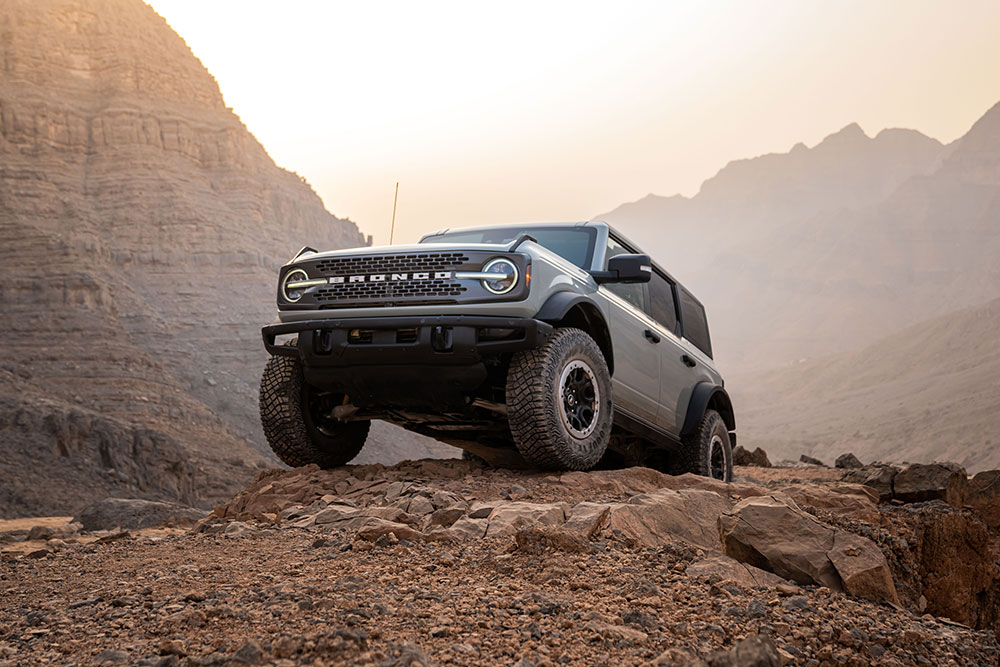 Un Ford Bronco grigio parcheggiato su un percorso roccioso in montagna.
