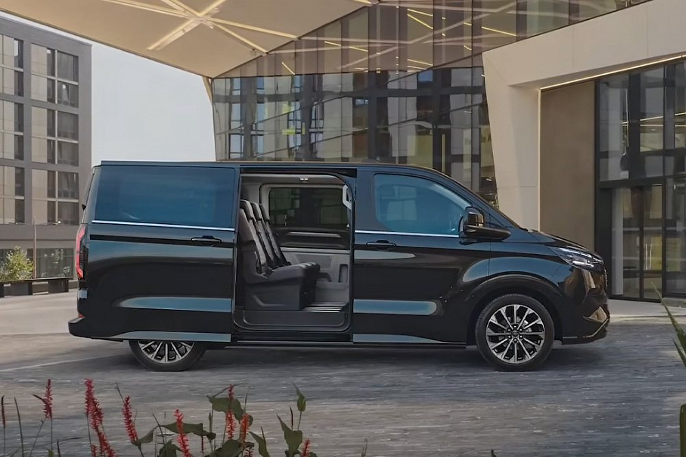 Un Ford E-Tourneo Custom nero parcheggiato con la porta laterale aperta, con vista sui sedili interni.