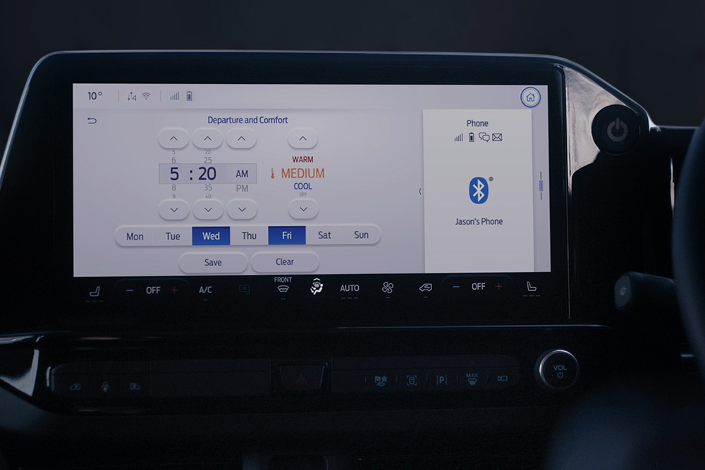 La schermata della dashboard dell'E-Tourneo Custom mostra le impostazioni di partenza e comfort, tra cui il pre-condizionamento programmato.