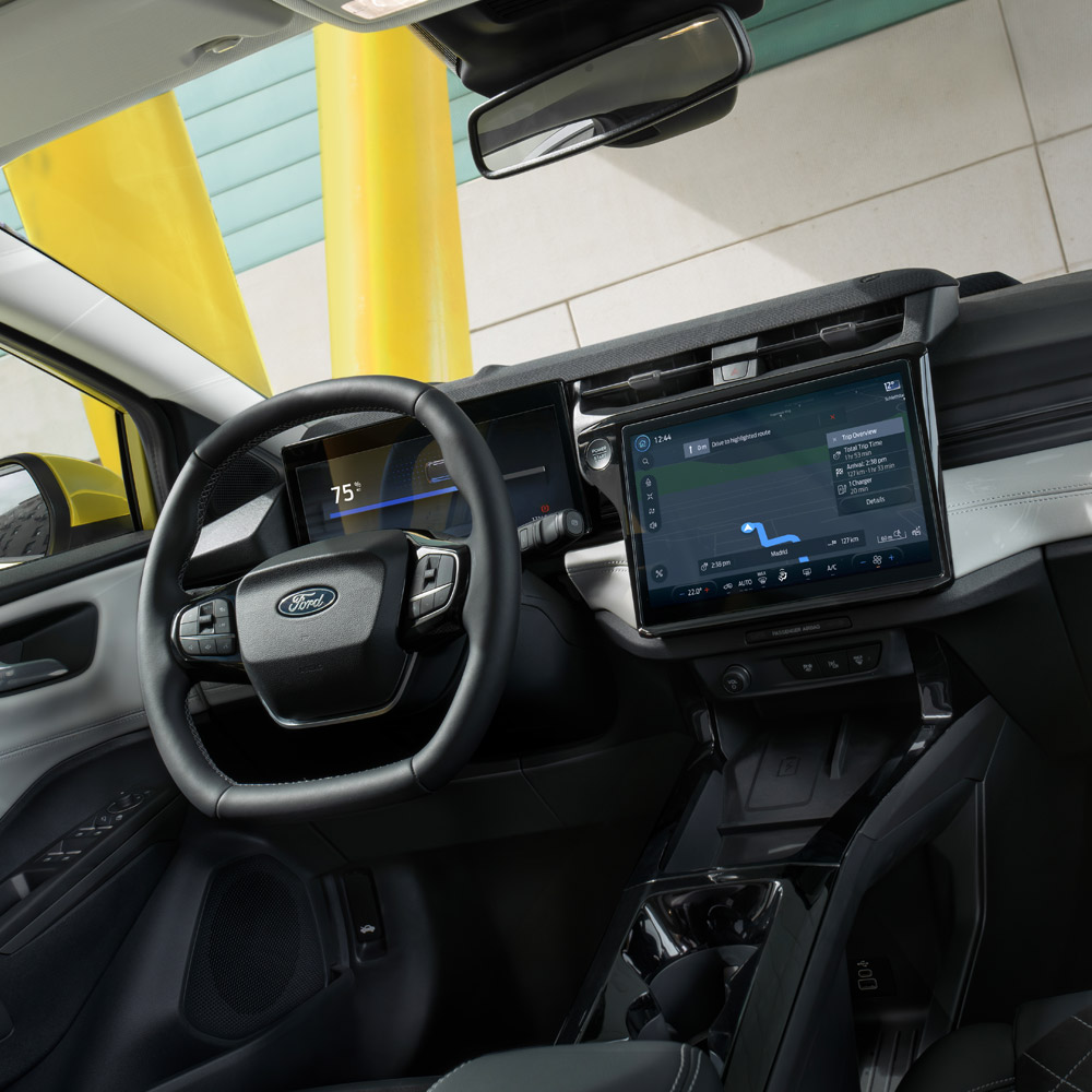 Vista sugli interni di una Ford Puma, con primo piano del volante e del touchscreen.