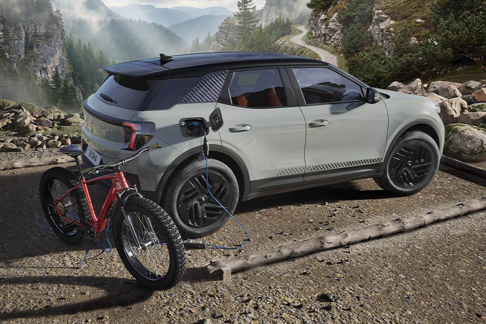 Una bici elettrica in carica da una Ford Explorer®, con un paesaggio montano sullo sfondo.
