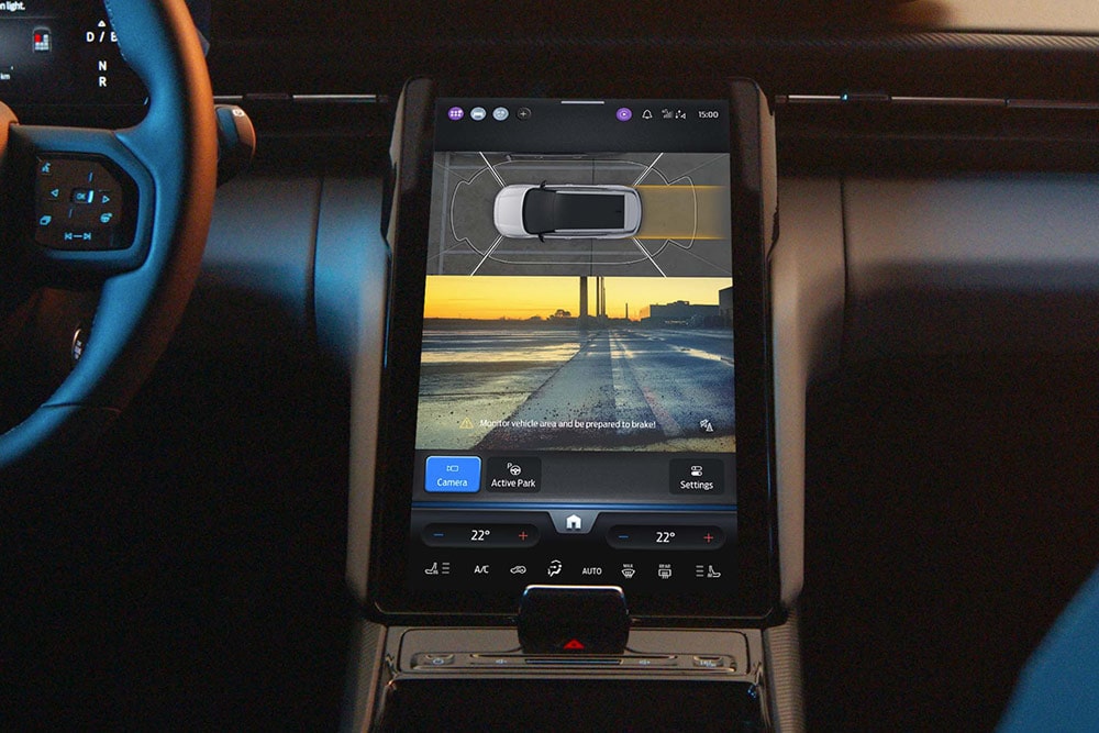 Primo piano del touchscreen di un SUV Ford che mostra il sistema di assistenza attiva al parcheggio in uso.