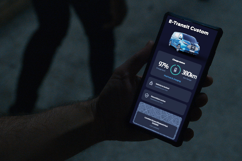 Uno smartphone mostra lo stato di ricarica e la posizione dell'E-Transit Custom nell'app FordPass.