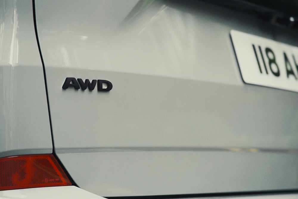 Parte posteriore di un Ford Tourneo Custom argentato, con lo stemma "AWD".
