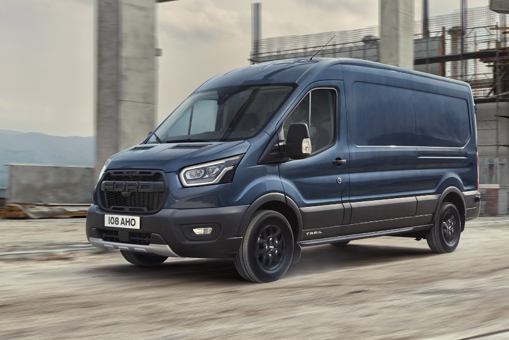 Furgone Ford Transit blu scuro in movimento su strada.