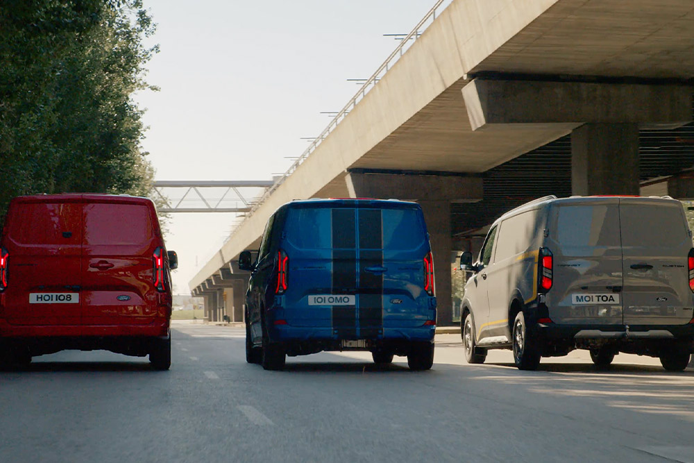 Tre furgoni Ford Transit Custom percorrono un tratto autostradale.