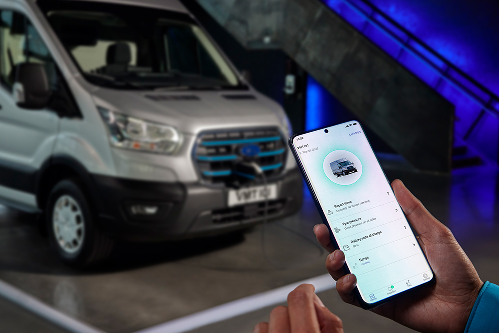Una mano che tiene uno smartphone sul quale è visibile l'app Ford E-Transit con visualizzate le informazioni sul veicolo.