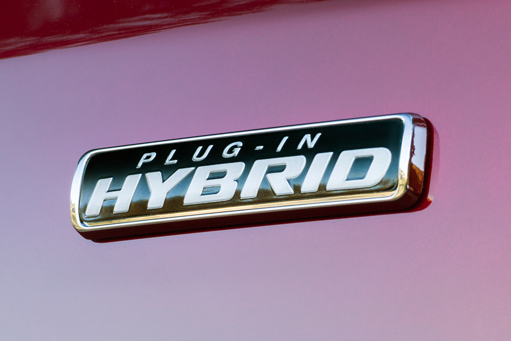 Stemma "Plug-in Hybrid" su un Ford Transit Custom rosso.