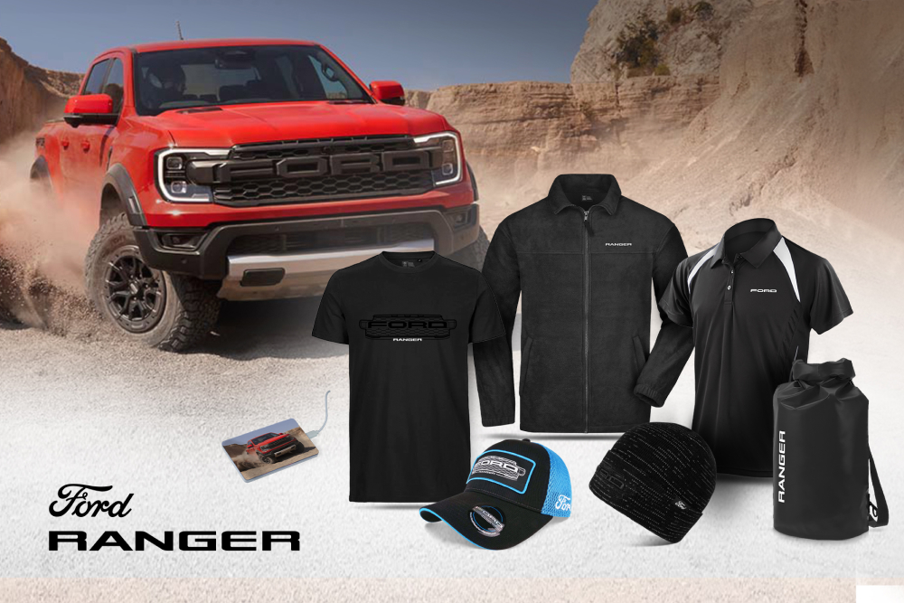 Una collezione Ford Ranger con maglietta nera, giacca, polo, cappellino, berretto e borsa, con un Ranger rosso sullo sfondo.