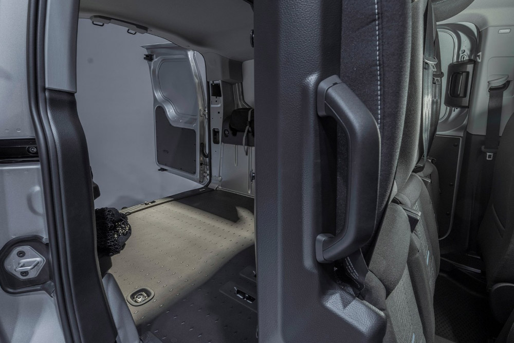 Sedili posteriori ribaltati e area di carico vuota all'interno di un Ford Transit Connect FlexCab Active.