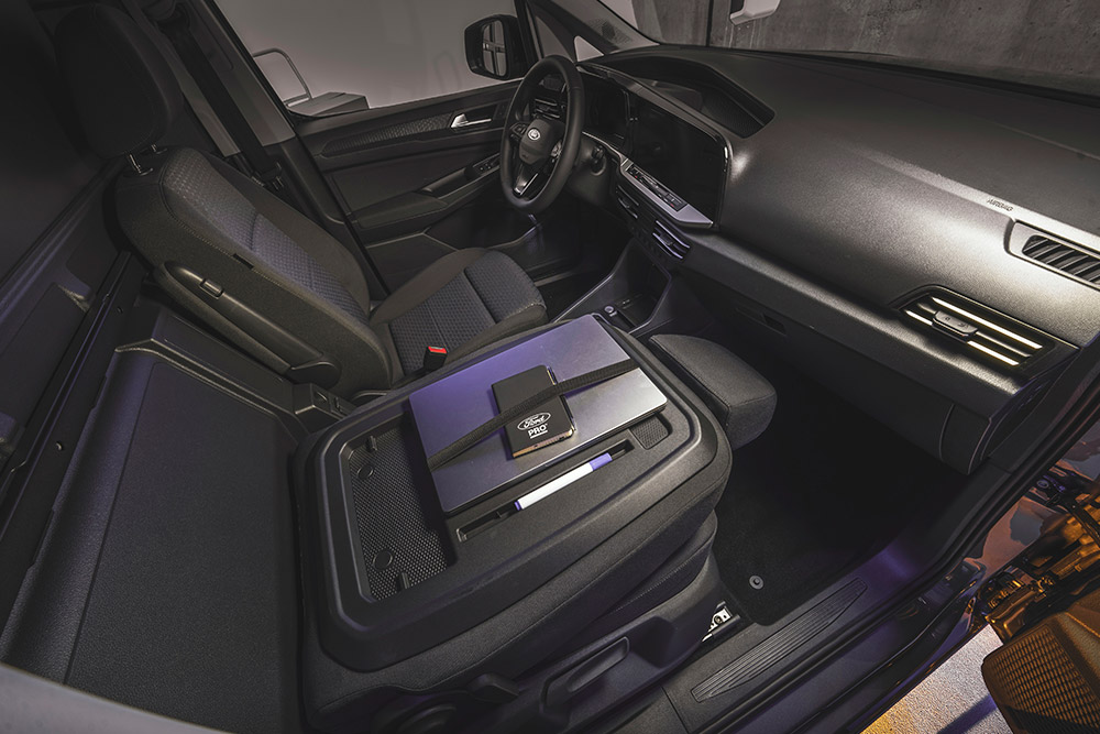 Interni Ford Transit Connect: cruscotto, sedili, laptop e smartphone sulla console centrale.