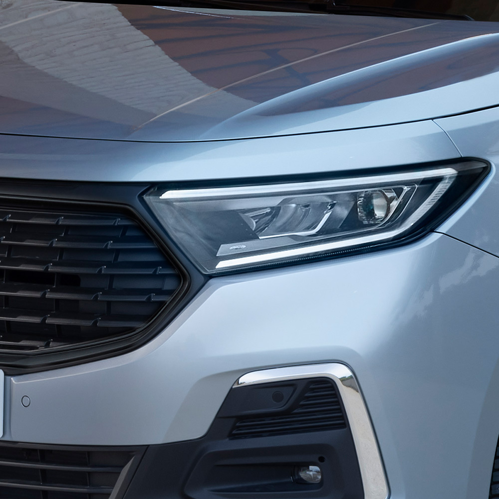 I fari automatici e l'elegante griglia frontale di un Ford Transit Connect versione Frost Silver.