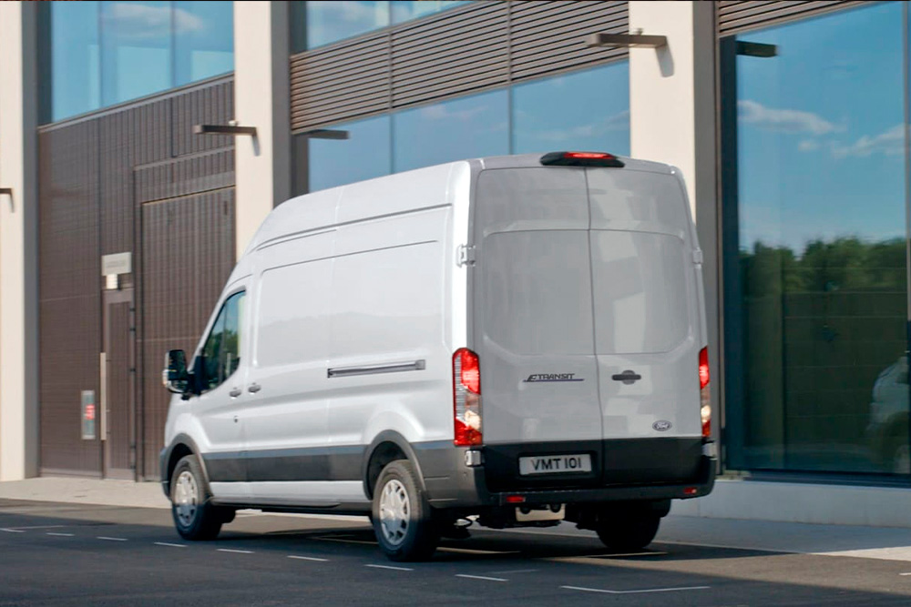 Retro di un furgone Ford Transit versione argento parcheggiato su una strada di città.