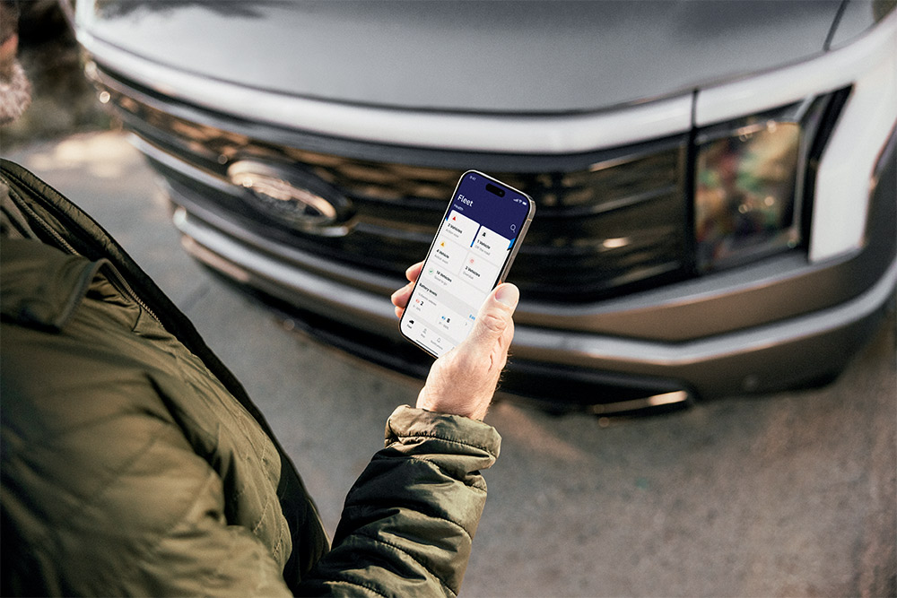 Un uomo che controlla il suo smartphone davanti a un Ford Ranger.
